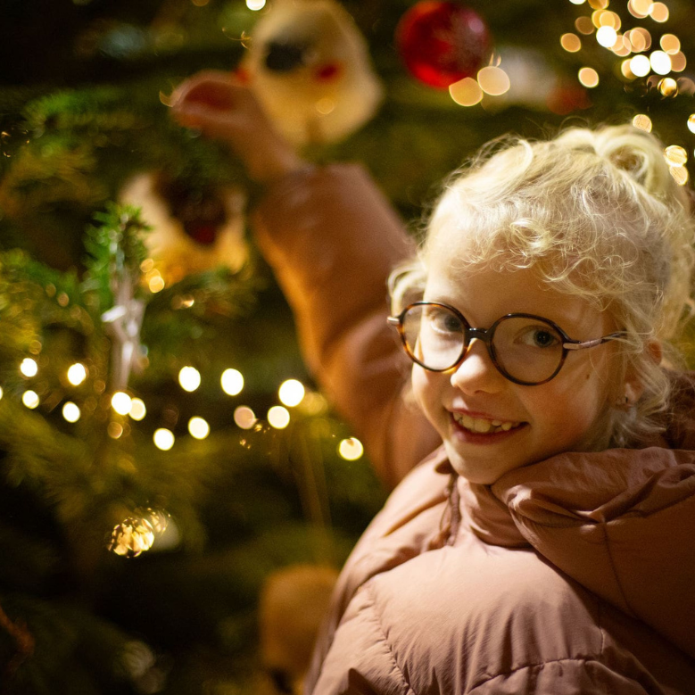 Kind am leuchtenden Weihnachtsbaum in Wichtelhausen